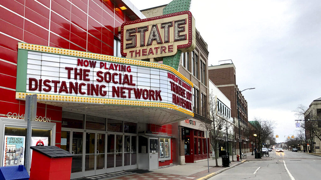 A movie theater marquee displays the message The Social Distancing Network.